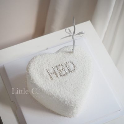 白色系愛心蛋糕，散落雪花，搭配銀色蠟燭，浪漫一起度過美好的一天